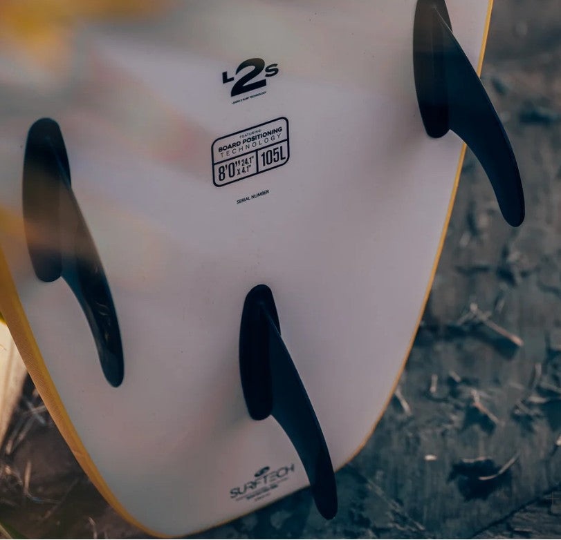Close-up of a surfboard with fins on a textured surface