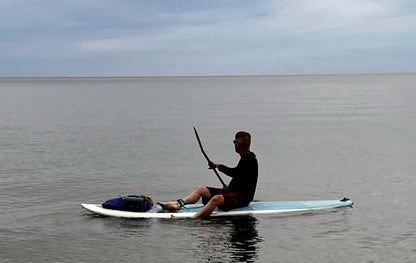 Person paddleboarding on a calm body of water