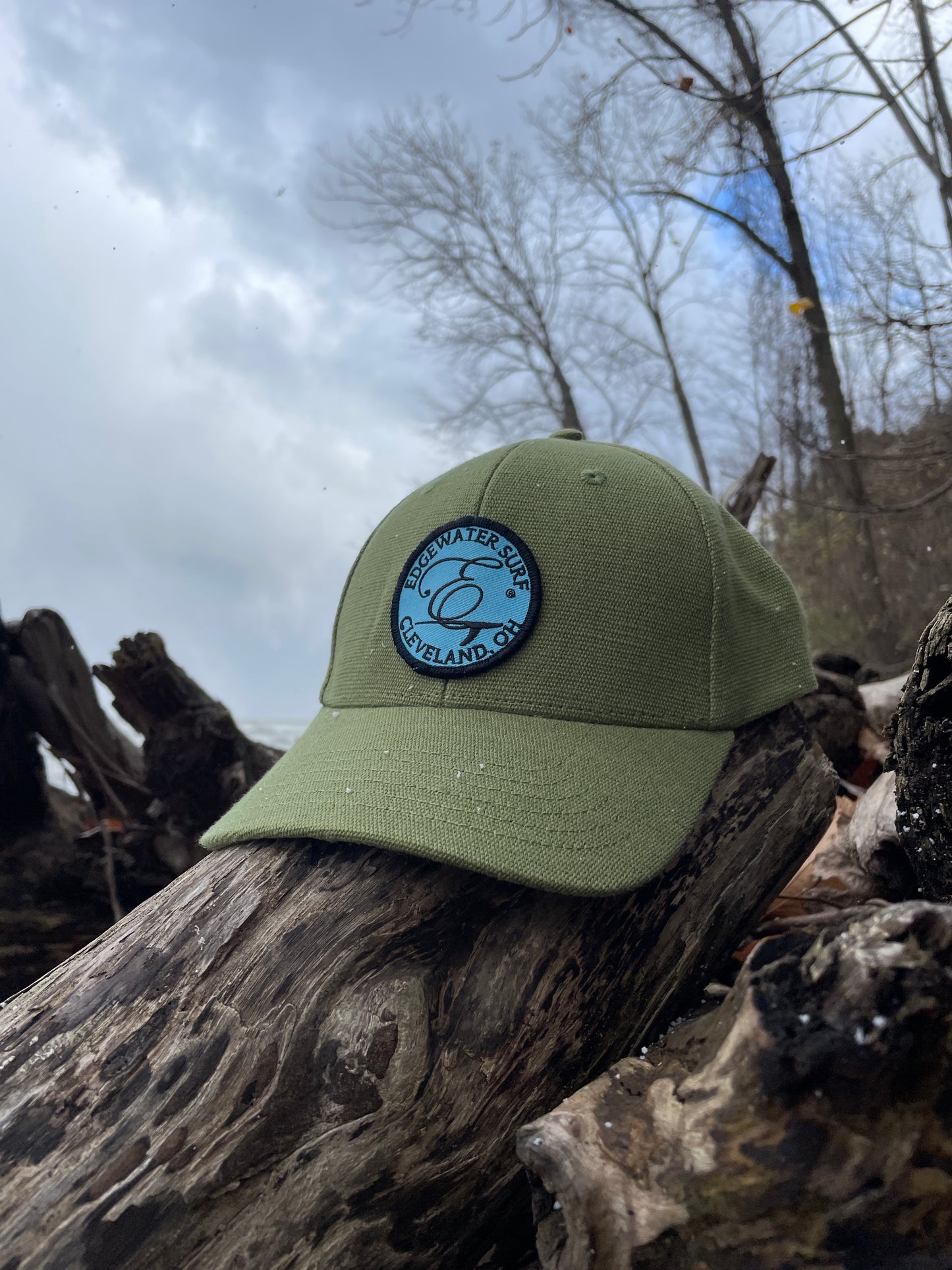 Green cap with a logo on a wooden log against a snowy background