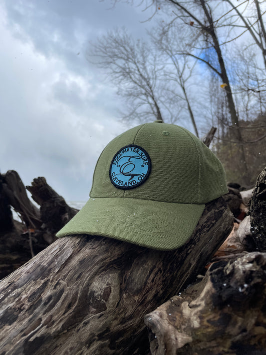 Green cap with a logo on a wooden log against a snowy background