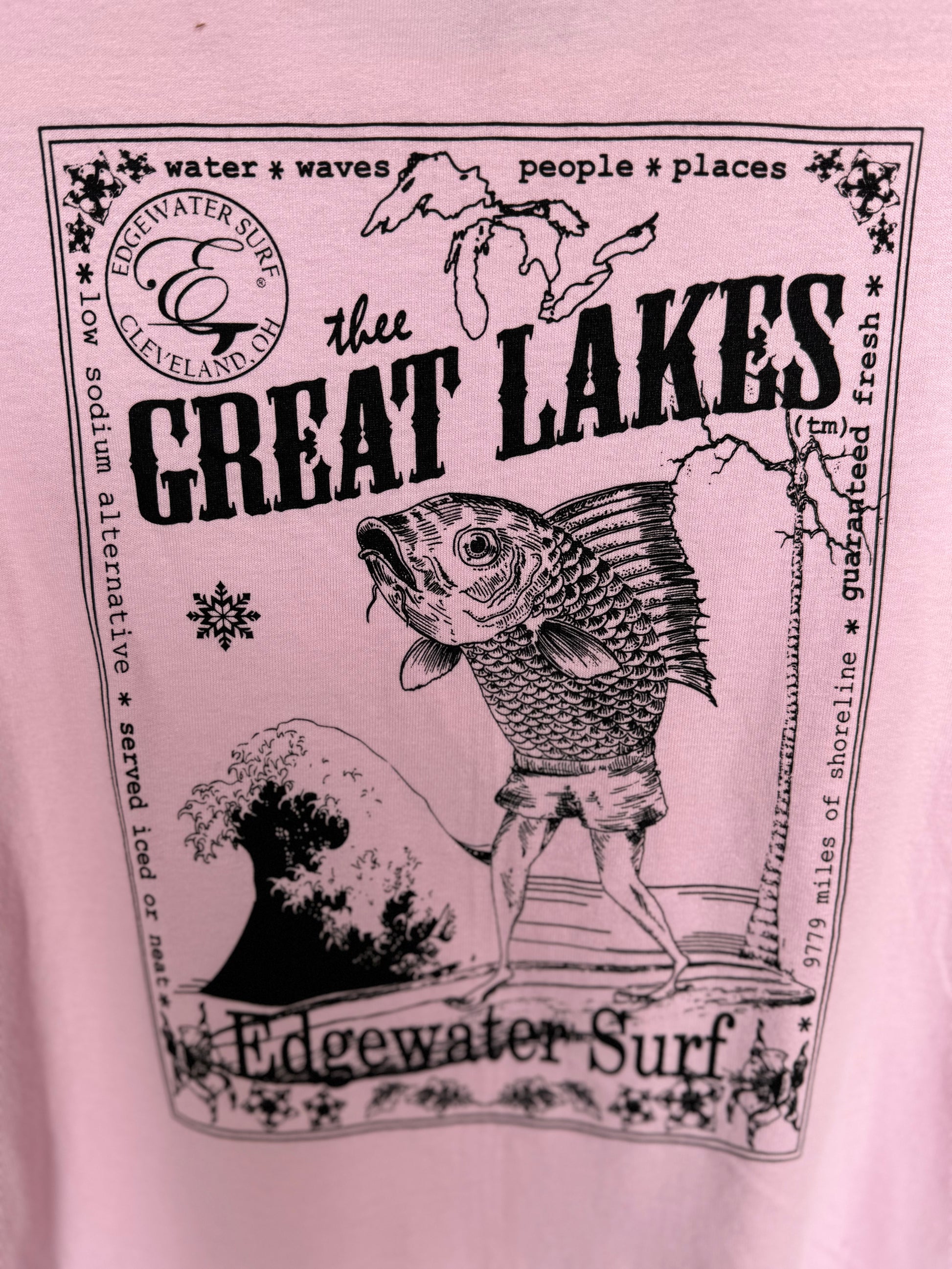 Pink t-shirt with black graphic design featuring a fish and text on a pink background